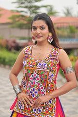 Woman wearing a colorful traditional outfit with floral patterns outdoors.