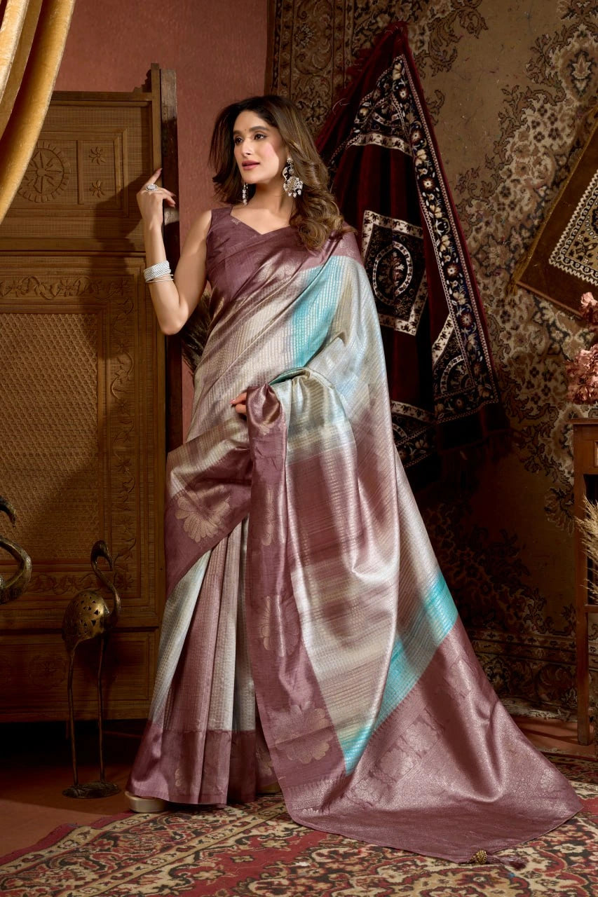 Woman in a saree standing in a decorated room with patterned walls and furniture.