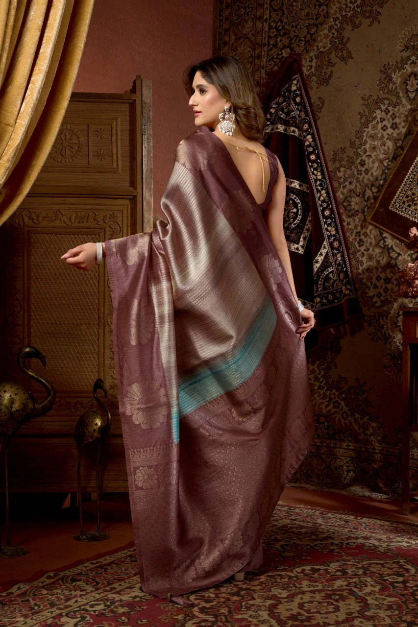 Woman in a traditional saree standing in an ornate room with decorative elements.