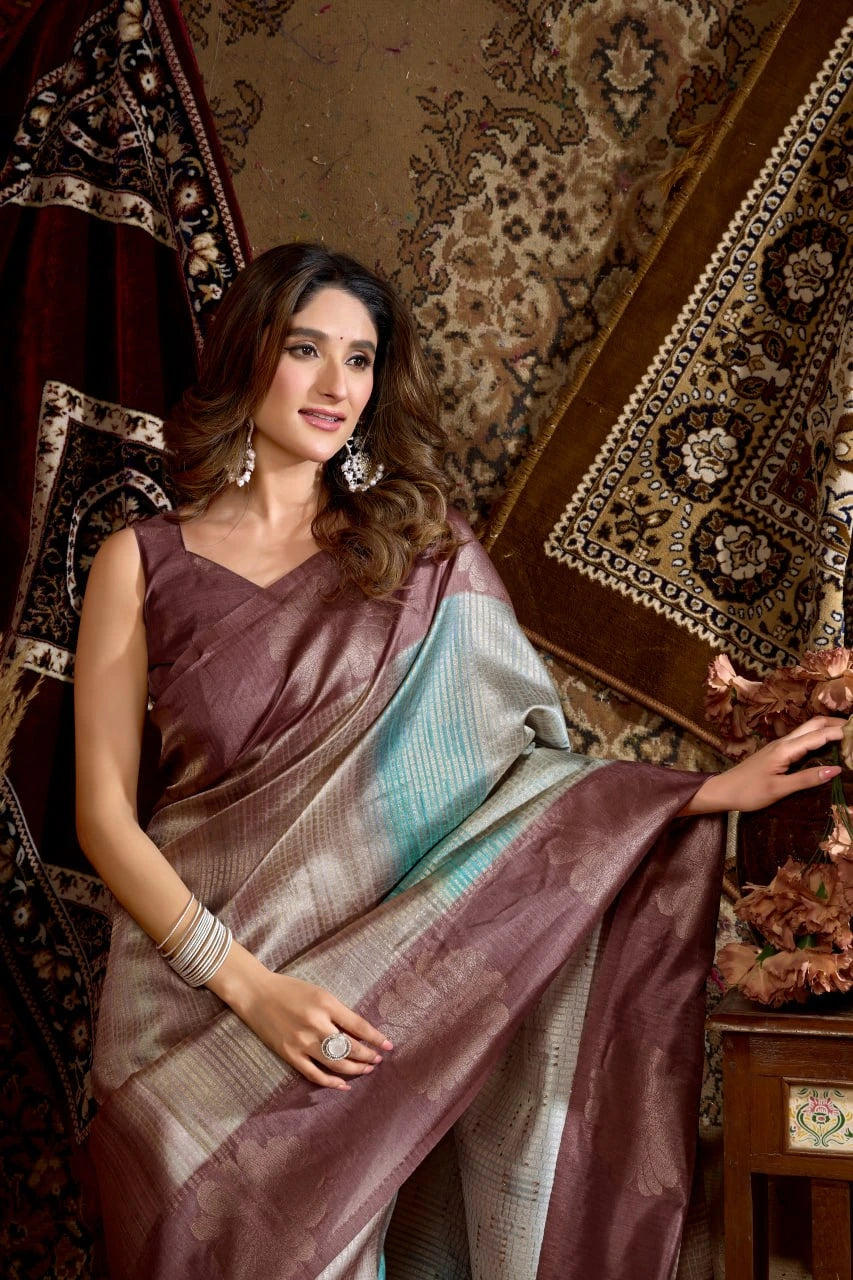 Woman in a saree sitting in an ornate room with patterned walls.