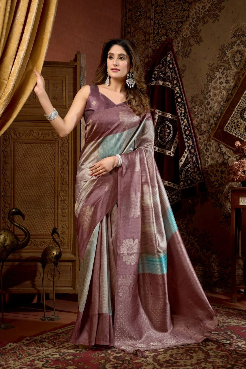 Woman in a traditional saree standing in an ornate room.