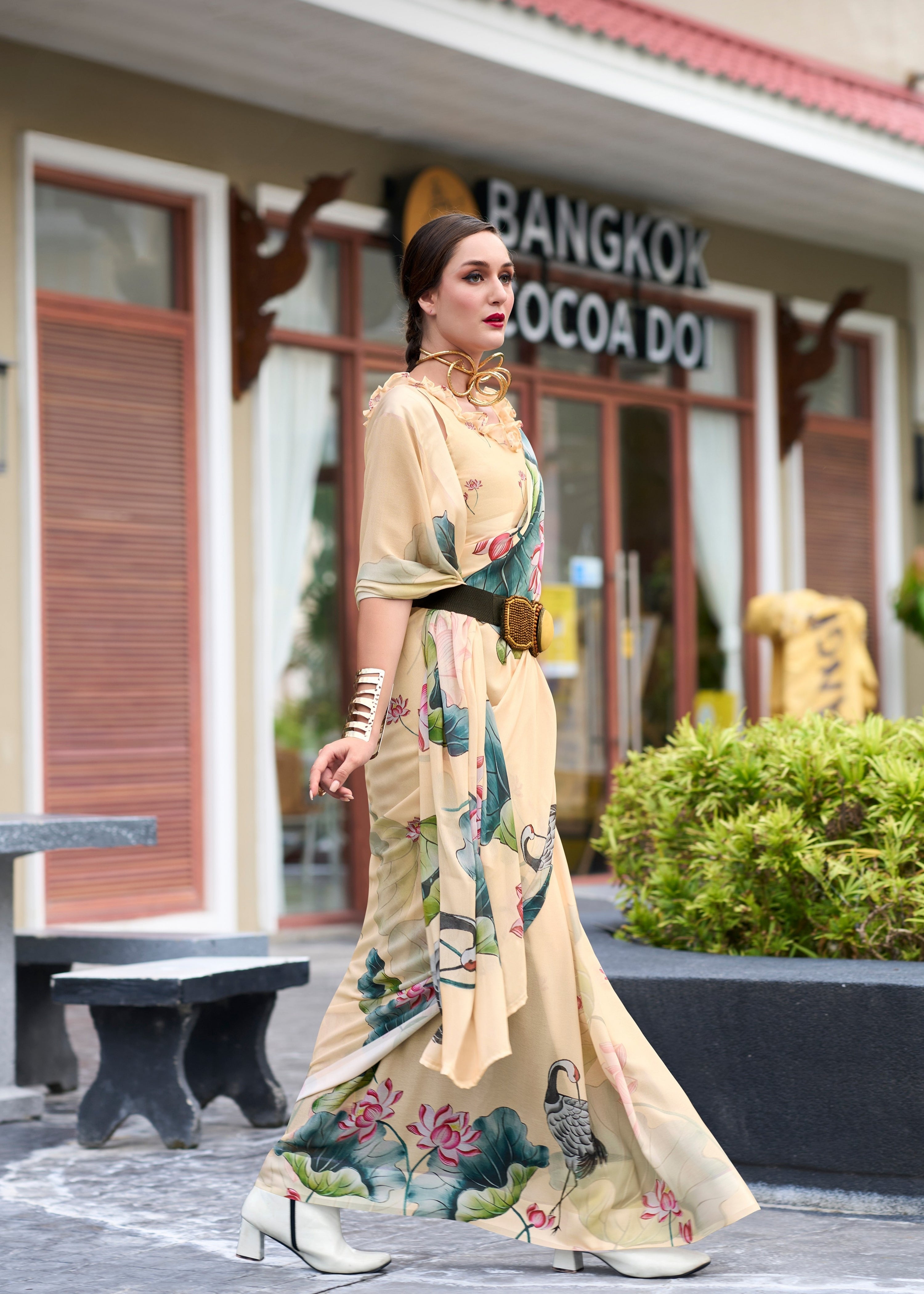 Woman in a floral dress standing in front of a building with 'Bangkok Cocoa' sign.