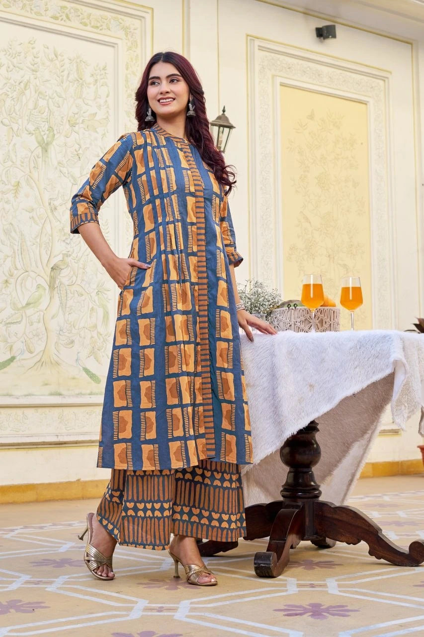Woman in a patterned dress standing in an elegant room with a table and chairs.