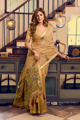 Woman in a traditional saree standing in a room with decorative elements.