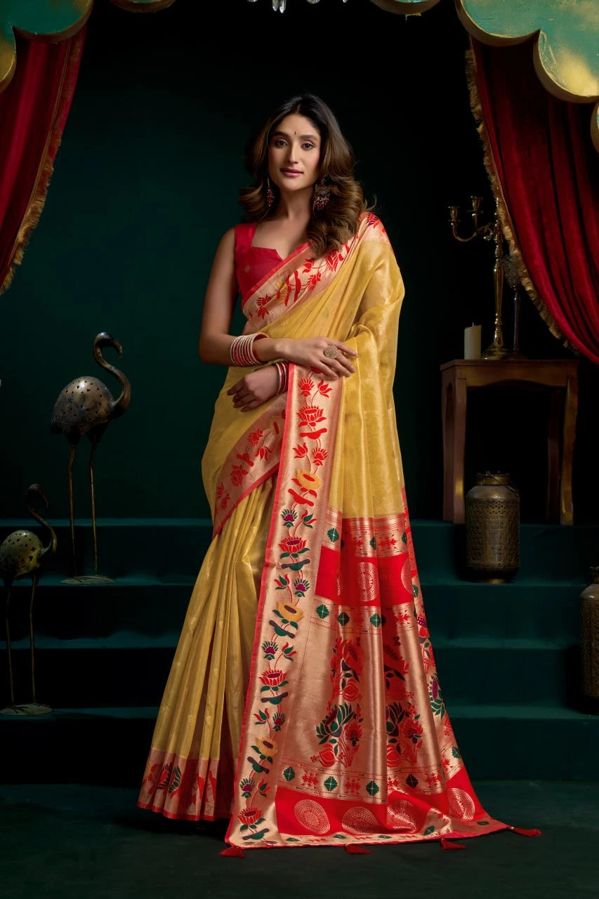 Woman wearing a yellow and red saree with a dark background