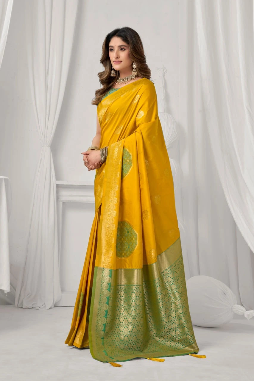 Woman wearing a yellow and green saree with a white curtain background