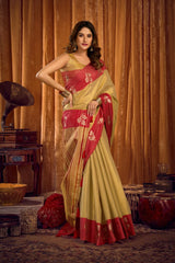 Woman in a red and yellow saree standing in a decorated room with curtains and vintage items.