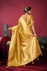 Woman in a gold saree standing against a red background