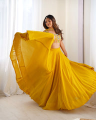 Woman in a yellow traditional outfit with a flowing skirt against a white curtain background