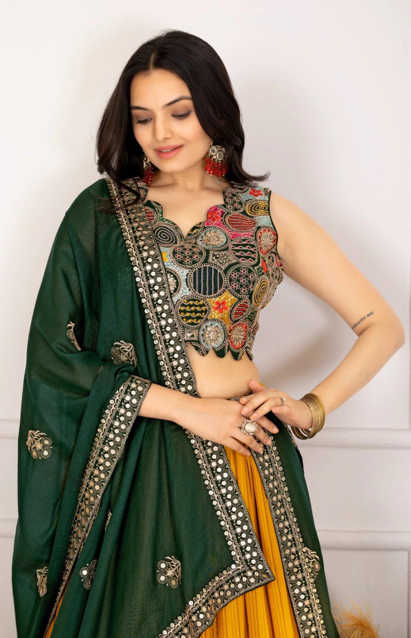 Woman wearing a green and yellow traditional outfit with intricate embroidery.