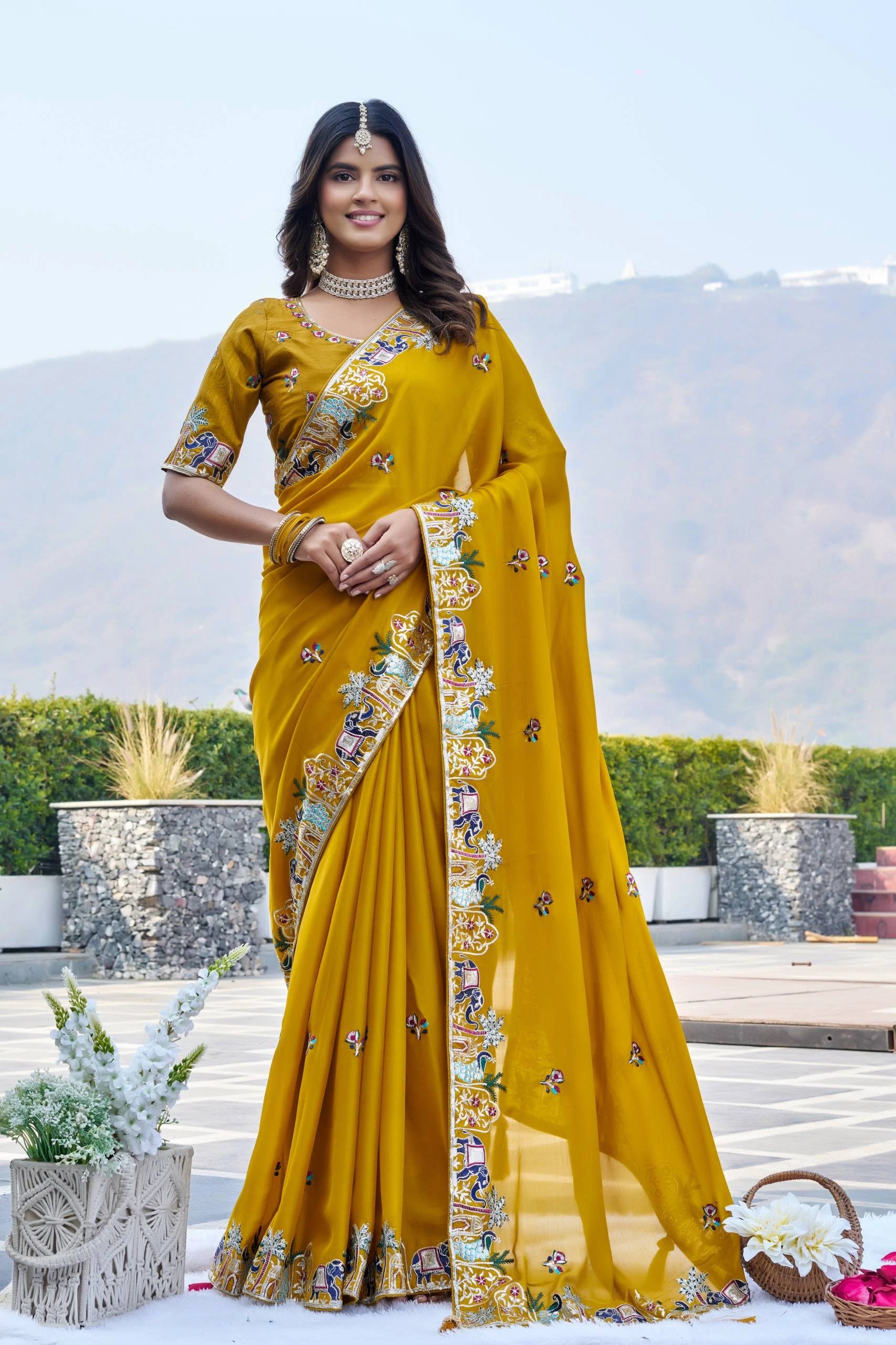Woman wearing a yellow saree with floral patterns outdoors