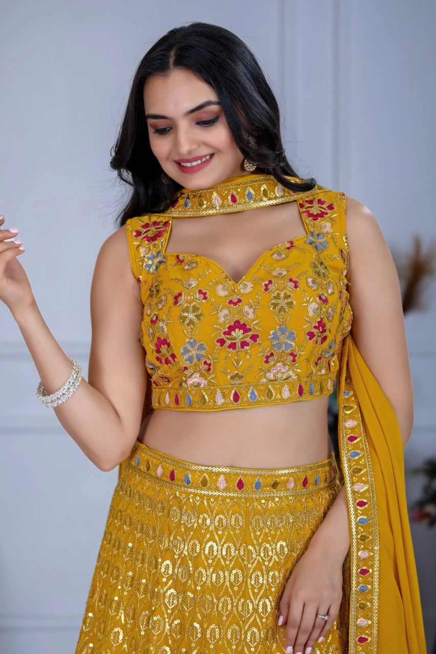Woman wearing a yellow embroidered traditional outfit with a plain background