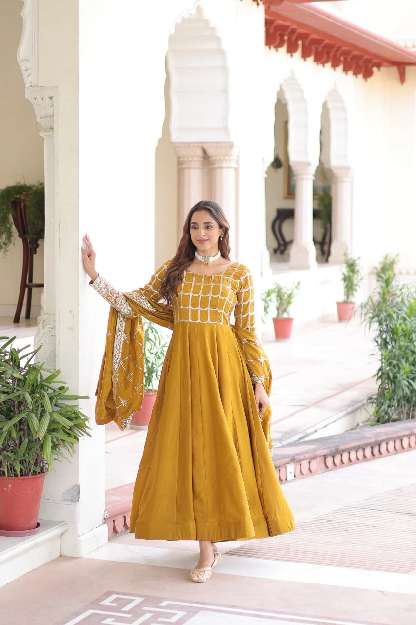 Woman in a yellow dress standing in front of a decorative building with plants.