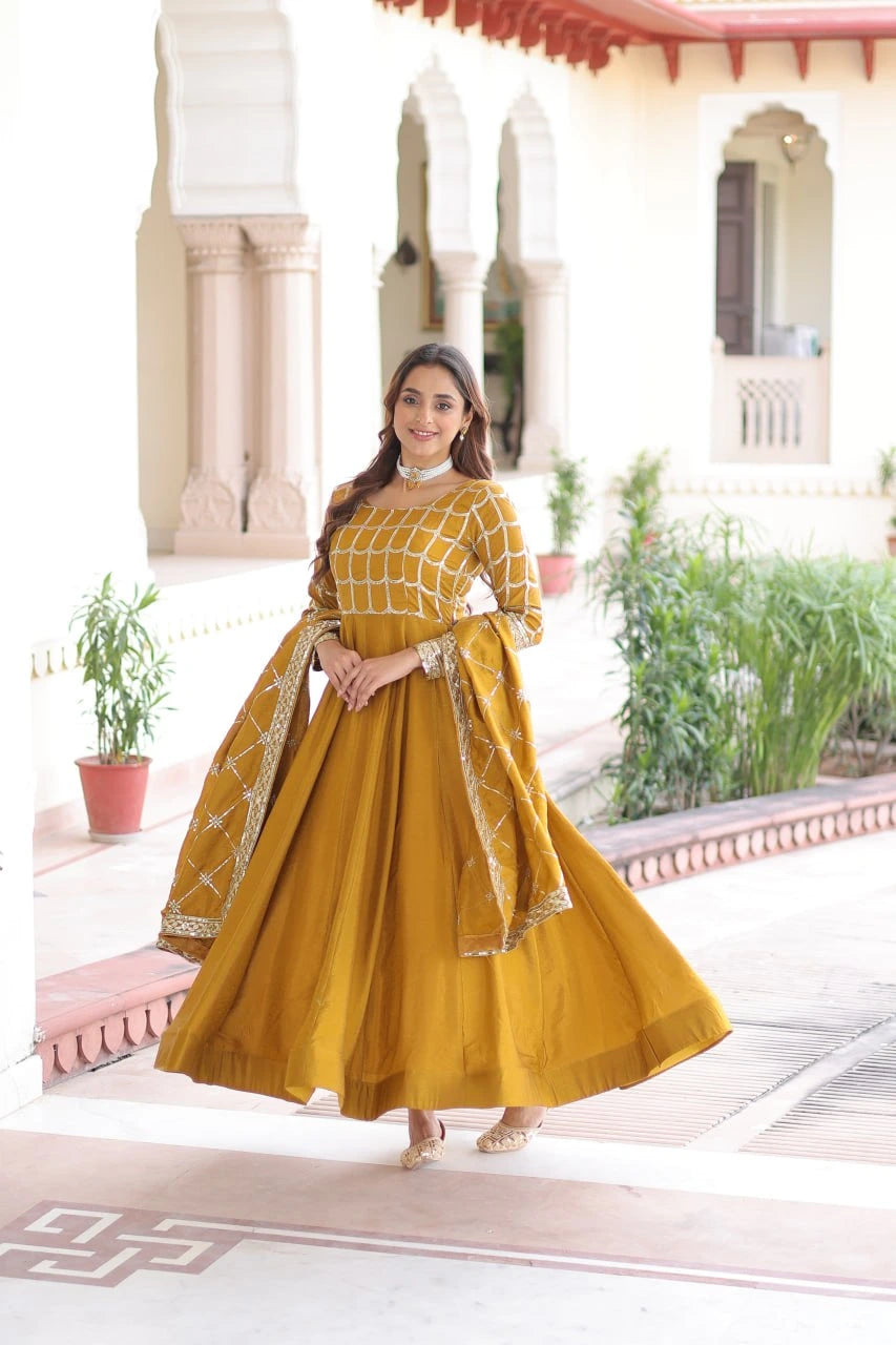 Woman in a yellow traditional outfit standing in front of an architectural building.