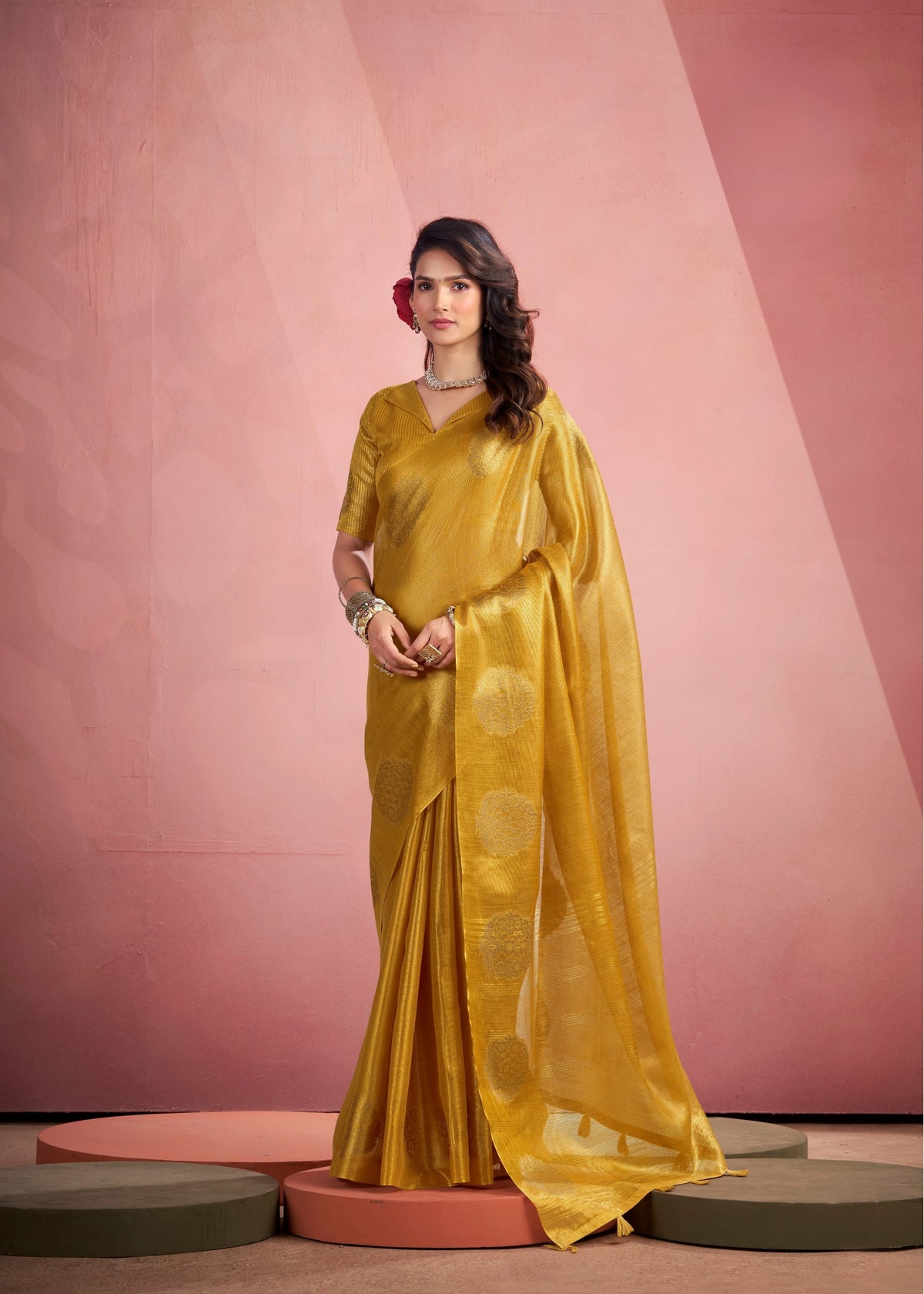 Woman wearing a yellow saree with a pink background