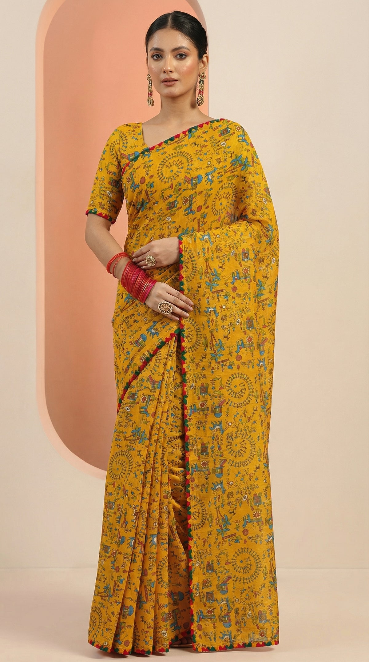 Woman wearing a yellow saree with a pattern on a beige background