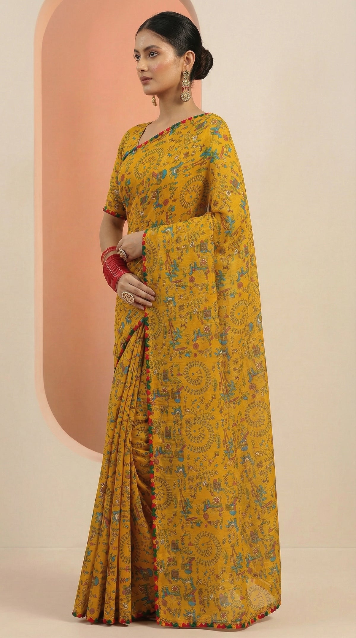 Woman wearing a yellow floral saree with a peach background