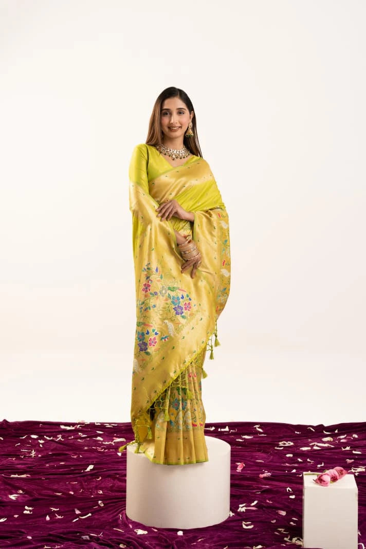 Woman wearing a yellow saree with a floral pattern on a white background