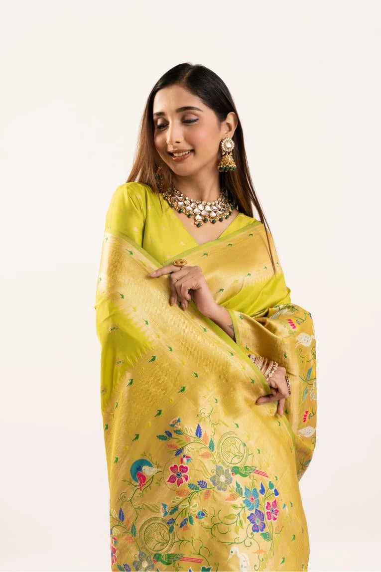 Woman wearing a yellow saree with floral patterns on a white background