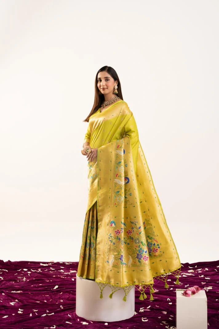 Woman wearing a yellow saree with a floral pattern on a white background