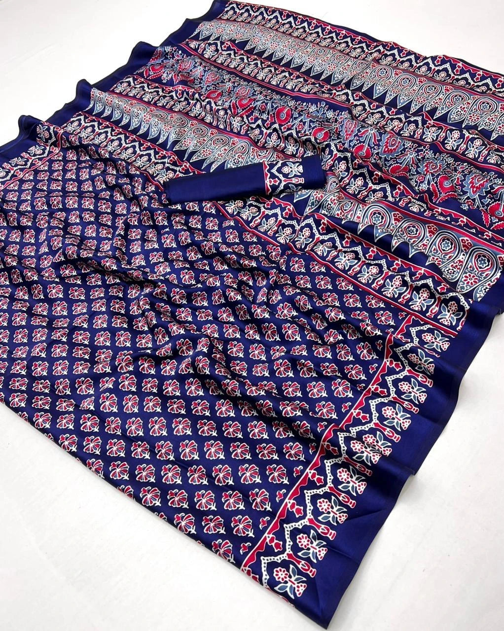 Blue patterned fabric with pink and white designs on a white background