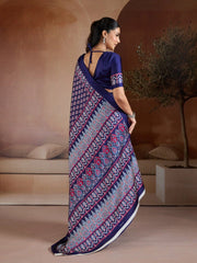 Woman wearing a blue and patterned saree in an indoor setting