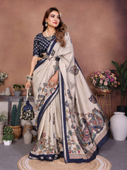 Woman wearing a traditional saree with intricate patterns in a decorated indoor setting.