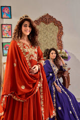 Two women in traditional outfits standing in a room with decorative elements.