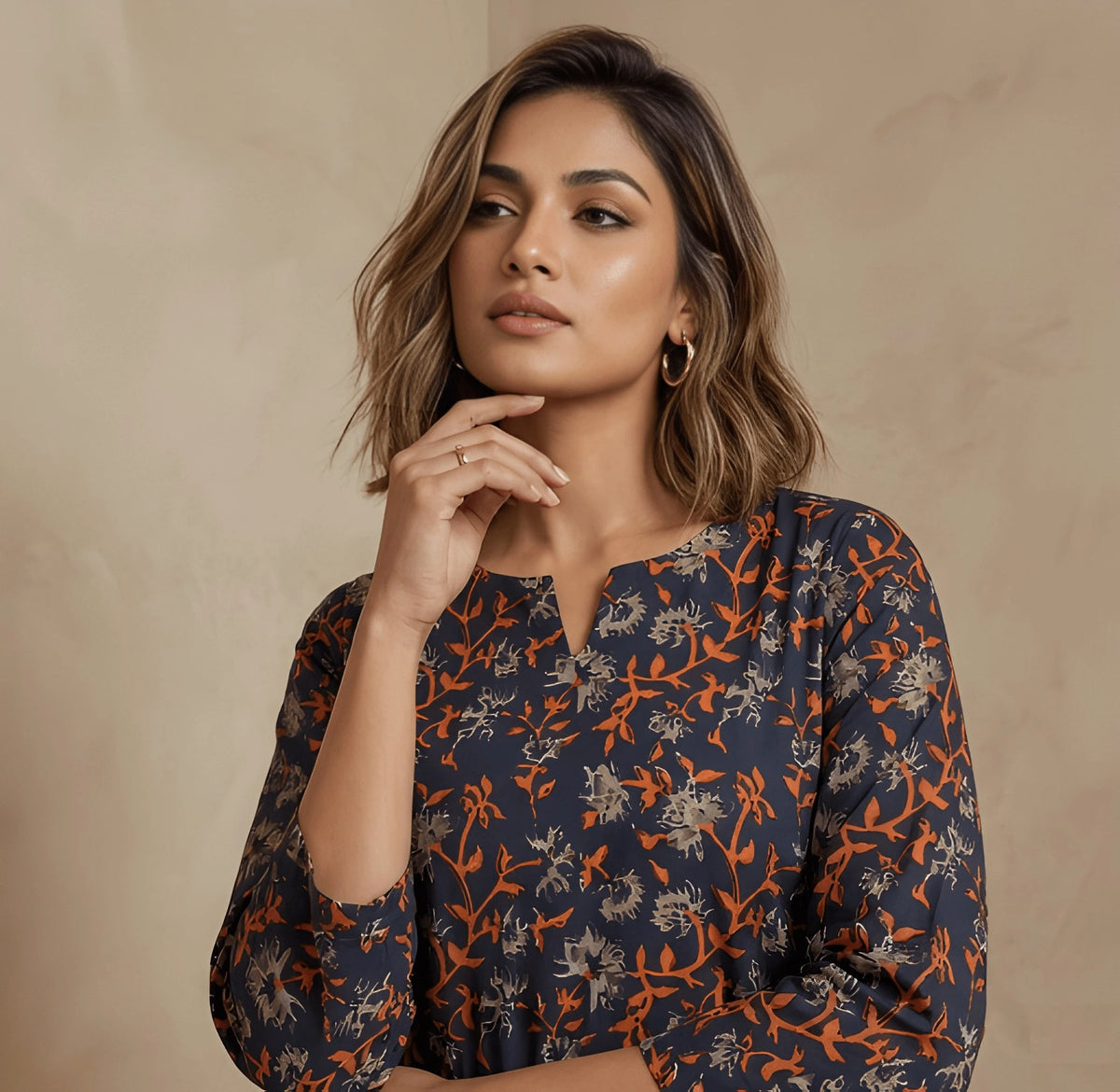 Woman wearing a patterned dress against a beige background