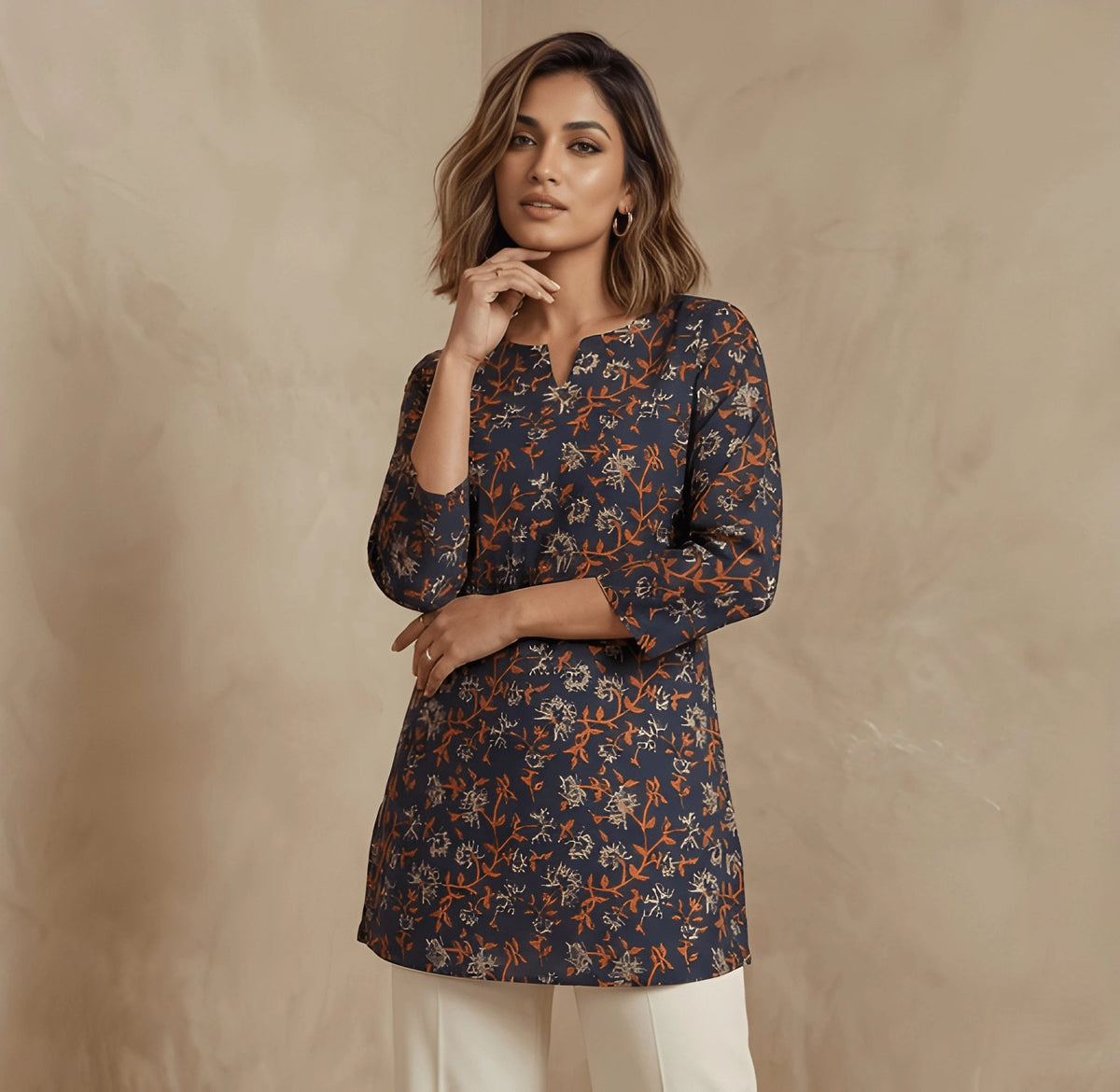 Woman wearing a patterned navy blue top against a beige background
