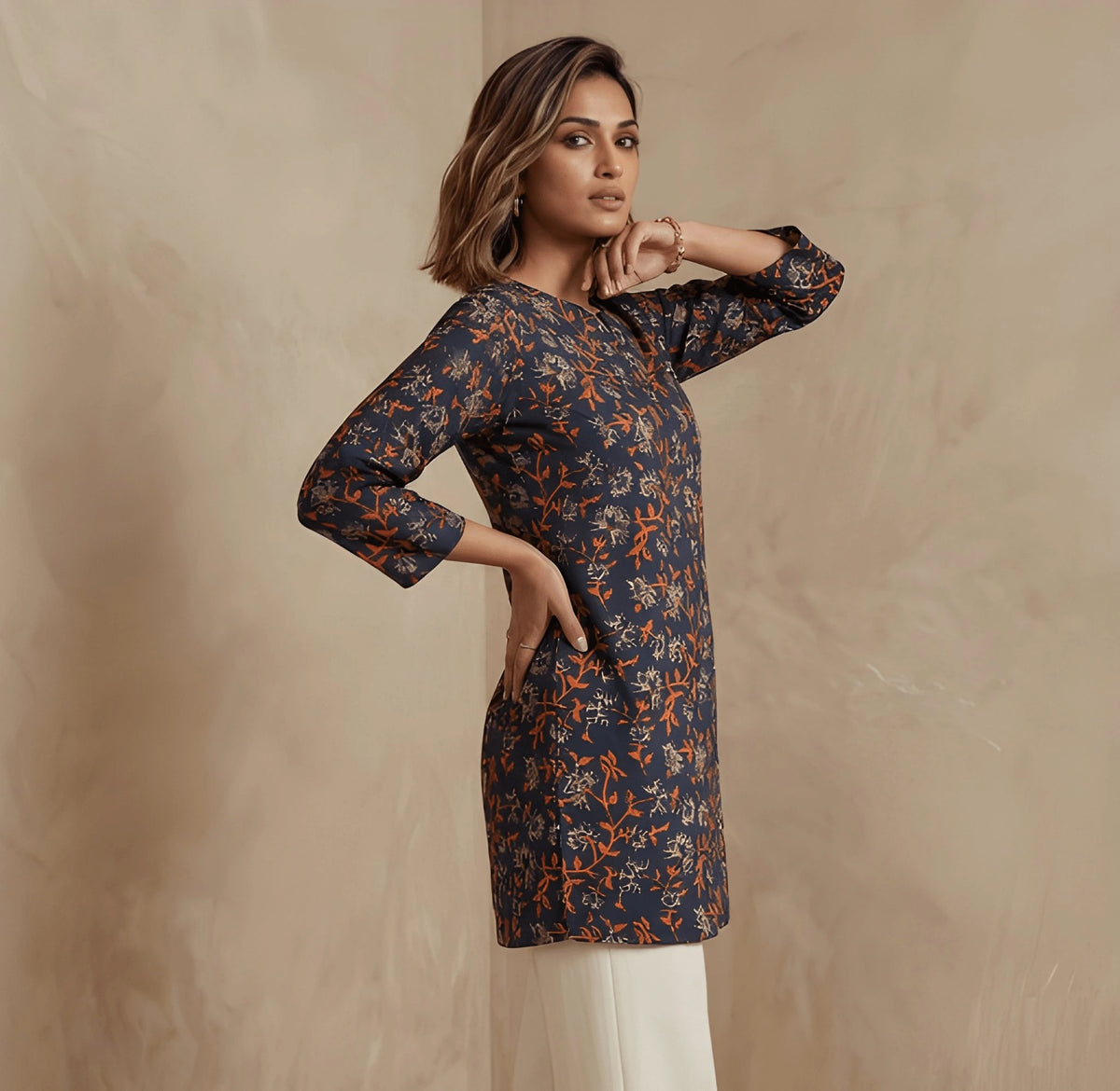 Woman wearing a patterned kurta against a beige background