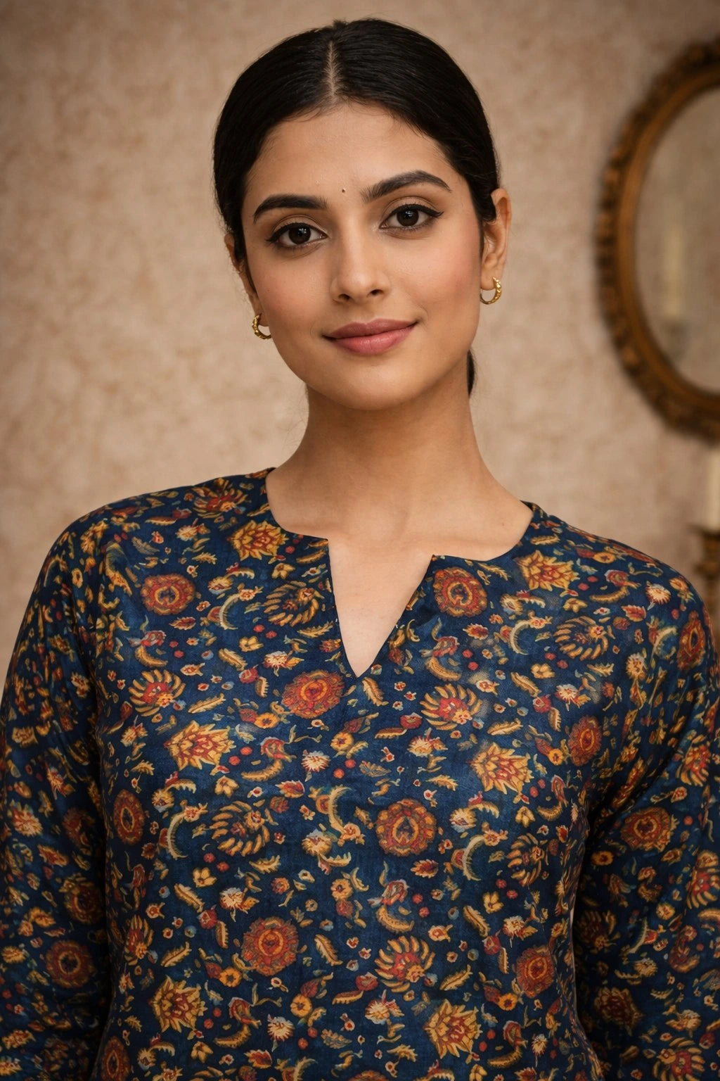 Woman wearing a dark blue floral patterned top against a neutral background