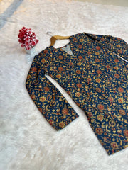 Floral-patterned shirt on a white textured surface with a small bouquet of flowers.