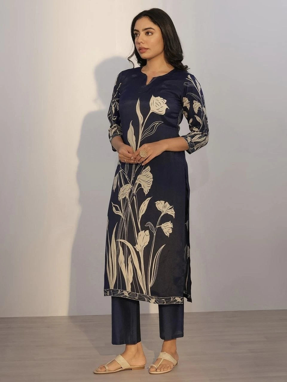 Woman wearing a navy blue kurta with floral patterns against a plain background
