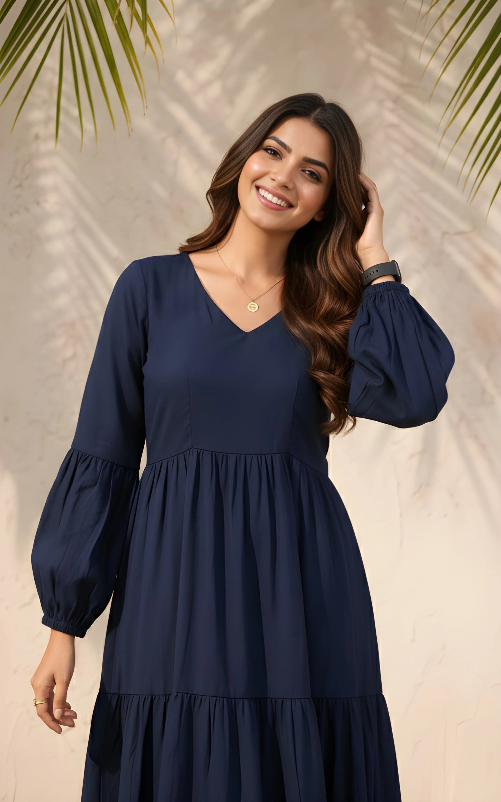 Woman wearing a navy blue dress with long sleeves against a neutral background