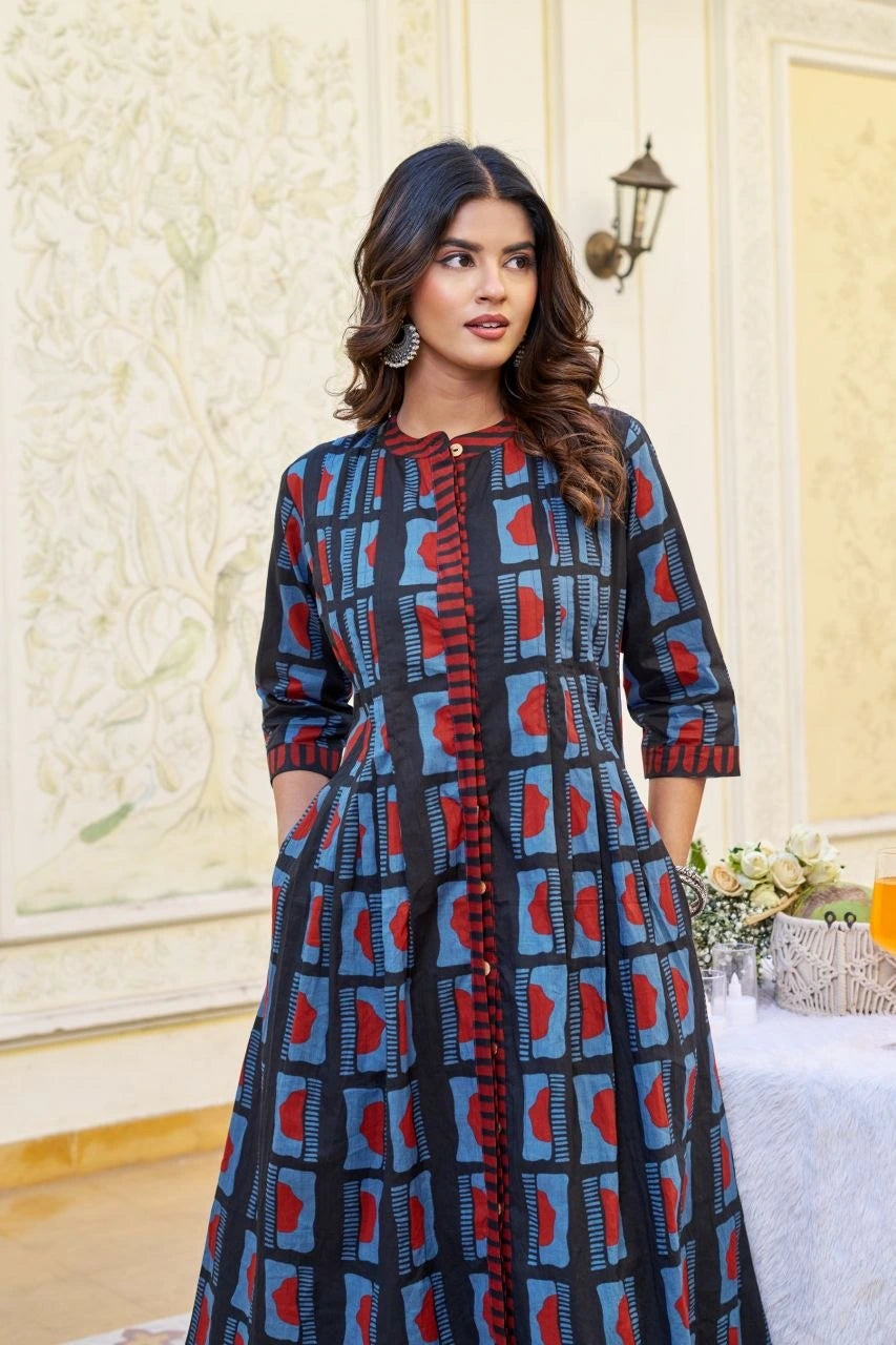 Woman wearing a blue and red patterned dress in an indoor setting.