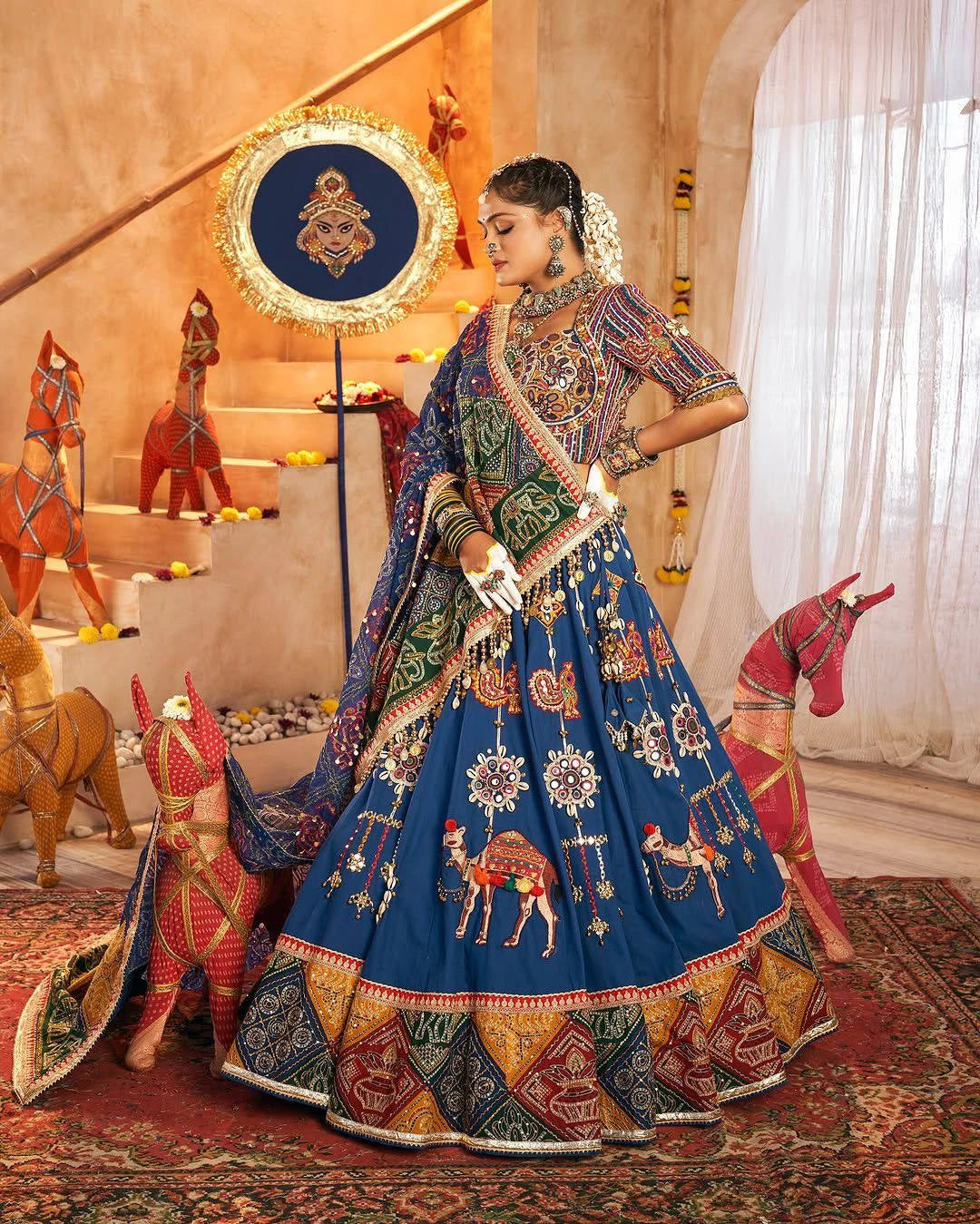 Woman in a colorful traditional outfit with intricate patterns in a decorated room.