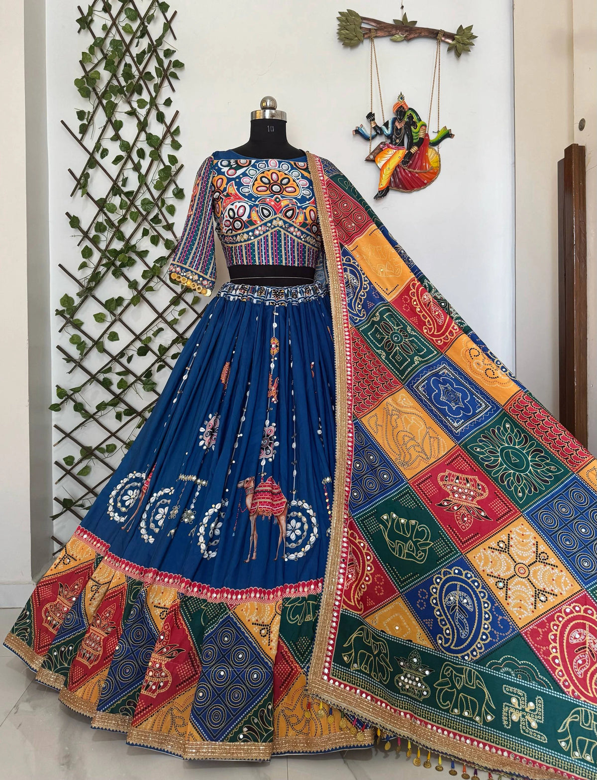 Colorful embroidered traditional outfit on a mannequin with a decorative background.