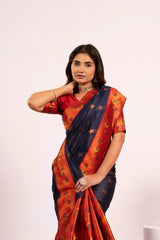 Woman wearing a traditional saree with a red and blue pattern on a white background