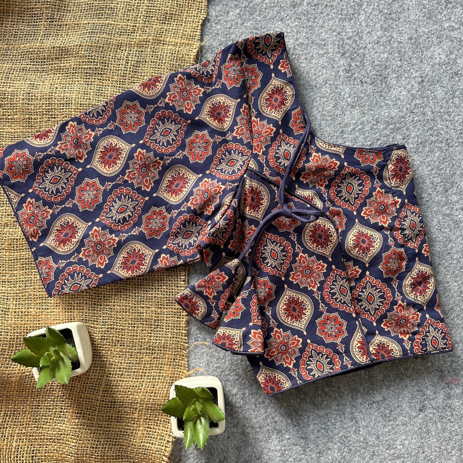 Green plants frame the garment beautifully.