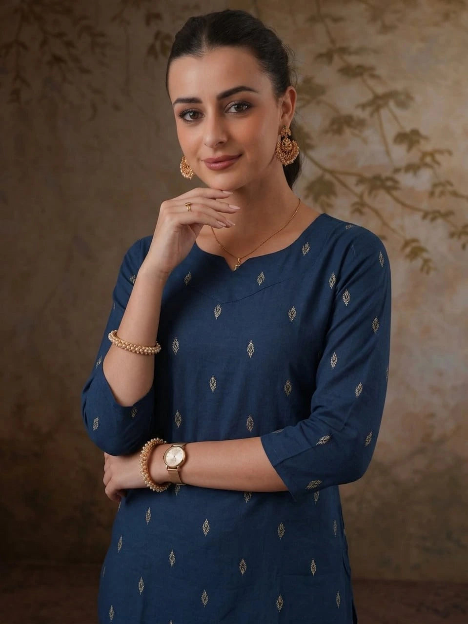 Woman wearing a blue dress with gold patterns against a brown background