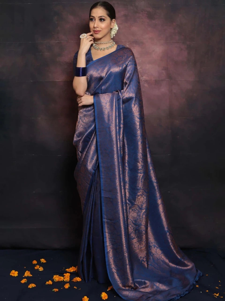 Woman wearing a blue saree with a dark background