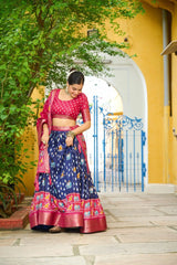 Woman in traditional Indian attire standing in front of a yellow building with an archway.