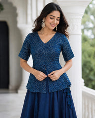 Woman wearing a blue patterned dress standing outdoors.