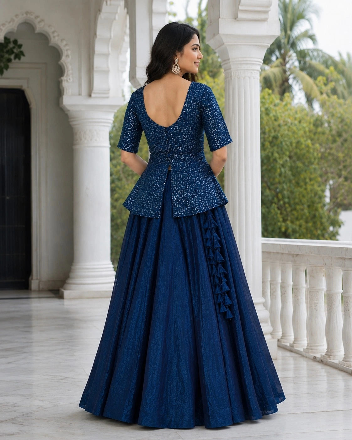 Woman wearing a blue evening gown with a white architectural background