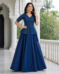 Woman wearing a blue traditional outfit standing outdoors.