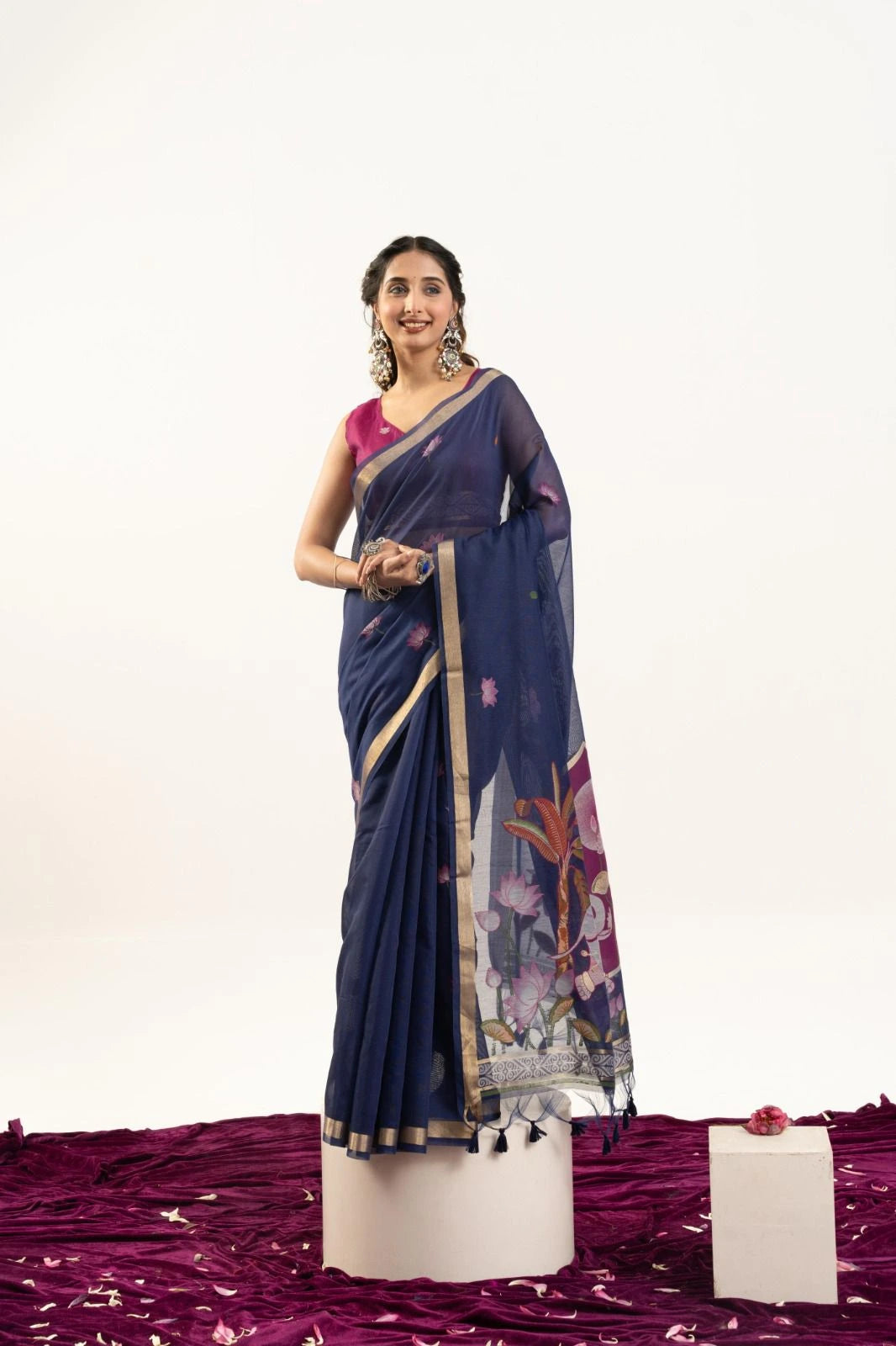 Woman wearing a blue saree with a floral pattern on a white background