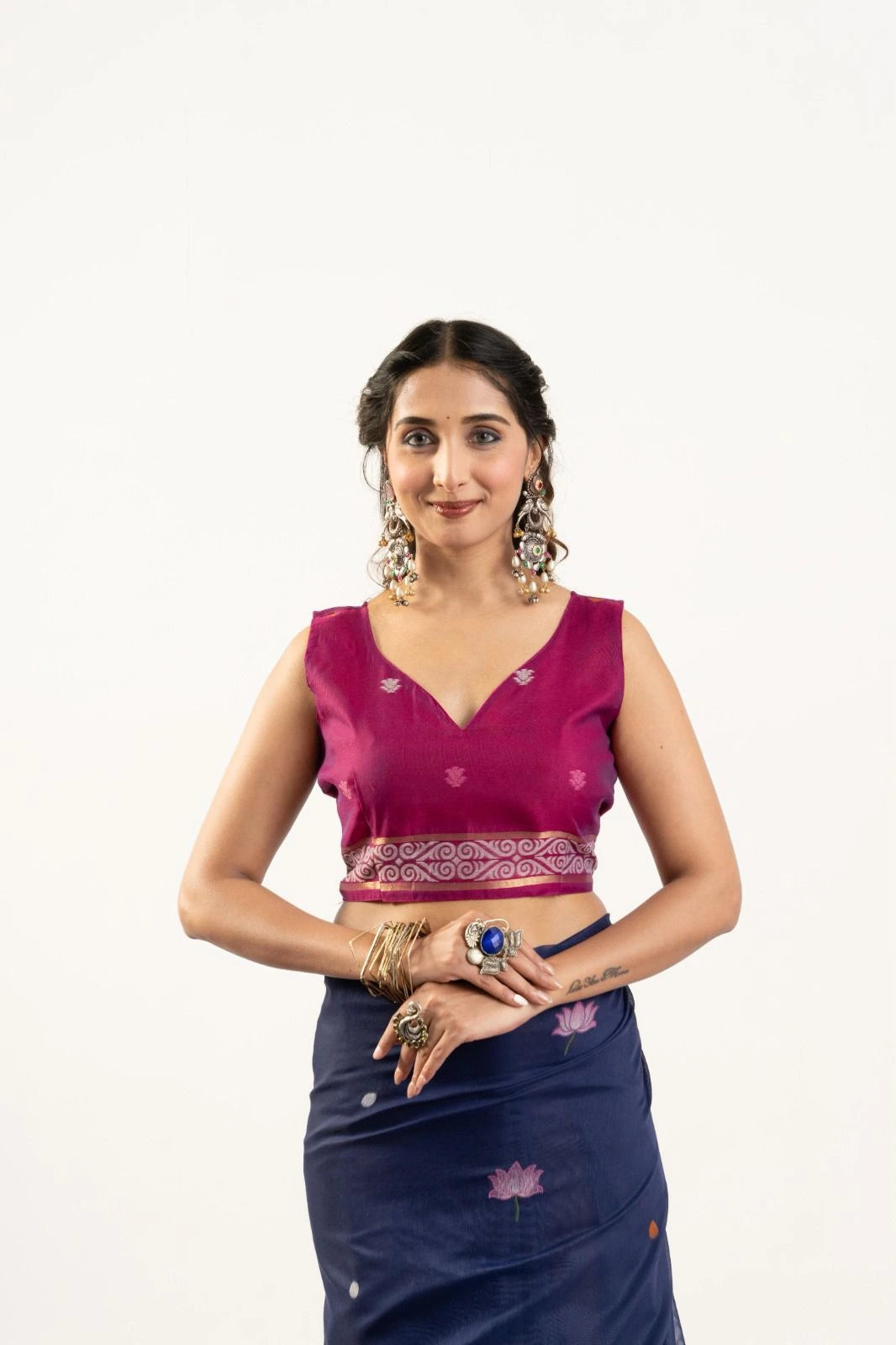 Woman wearing a pink blouse and blue saree with floral patterns on a white background