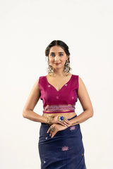 Woman wearing a pink blouse and blue saree with floral patterns on a white background