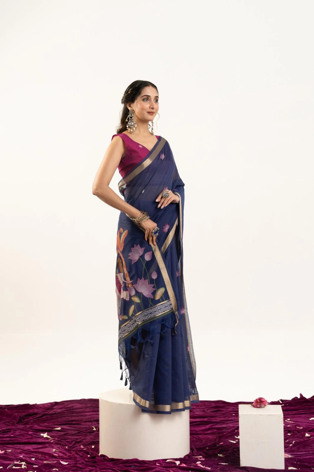 Woman wearing a blue saree with a floral pattern on a white background